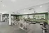 Modern fitness center with state-of-the-art equipment, including treadmills and weight machines, set in a spacious layout with elegant green walls.