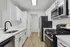 Modern kitchen design with sleek white cabinetry, stainless steel appliances, and elegant wood flooring.