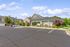 Charming apartment community nestled among lush greenery with ample parking and elegant architecture.