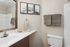 Elegant bathroom with sleek vanity, modern fixtures, and stylish wall art, creating a serene and inviting space.