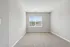 Bright and spacious room with plush carpet and a large window offering scenic views, perfect for a serene living space.