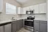 Modern kitchen with sleek stainless steel appliances, stylish two-tone cabinetry, and elegant marble countertops.