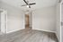 Modern living room with elegant wood flooring, ceiling fan, and ample natural light.