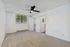 Inviting bedroom with soft carpet flooring, modern ceiling fan, spacious closet, and large window offering abundant natural light.