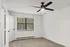 Bright, modern bedroom with plush carpet, sleek ceiling fan, and large window offering ample natural light.