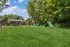 Lush green dog park with agility equipment, surrounded by trees and offering a vibrant outdoor space.