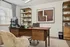 Sophisticated home office with a modern walnut desk, elegant shelving, and contemporary art, offering a serene and productive atmosphere.
