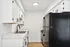 Elegant kitchen with sleek black appliances, modern white cabinetry, and stylish fixtures embodying contemporary sophistication.