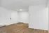 Bright minimalist entryway with sleek wooden floors and modern white walls.