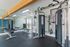 Modern fitness center with sleek exercise equipment, large mirrors, and ample natural light.