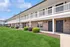 Charming apartment complex with elegant balconies, lush green lawns, and inviting brick facades.