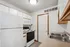Cozy, bright kitchen with modern white appliances, ample cabinet storage, and a sleek double sink.
