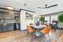 Modern apartment interior with elegant dining area, stylish kitchen cabinets, and cozy seating by large windows, enhanced by vibrant decor and lush greenery.