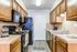 Cozy galley kitchen with elegant wooden cabinetry, modern appliances, and stylish tile backsplash offering a warm and inviting space.