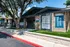 Inviting leasing office exterior with modern brick design and vibrant greenery, perfect for welcoming prospective residents.
