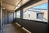 Charming apartment patio with modern design, featuring ample space and a view of neighboring buildings under a bright blue sky.