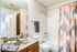 Bright and modern bathroom featuring a stylish shower curtain, granite countertop, and contemporary fixtures.