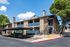 Charming residential apartment building with modern amenities and lush greenery, featuring spacious balconies and covered parking.
