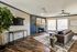 Elegant living room with modern decor featuring a sleek wall-mounted TV, stylish sofa, and a cozy fireplace accented by tasteful art pieces and abundant natural light.
