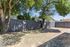 Inviting fenced backyard with lush trees providing shade and a serene atmosphere, perfect for outdoor relaxation.