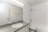Modern bathroom featuring a sleek countertop, elegant sink, and spacious bathtub with clean white tiles.