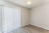 Bright room with wood-like flooring, modern ceiling light, and elegant vertical blinds inviting natural light.