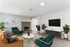 Modern living room featuring a cozy fireplace, stylish furniture, and abundant natural light, perfect for relaxation and entertaining.