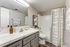 Modern bathroom with elegant marble countertop, large mirror, and stylish decor.