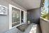 Charming balcony with elegant outdoor seating, contemporary design, and lush greenery views.