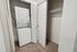 Modern apartment laundry area with a stacked washer and dryer next to a spacious closet with sliding doors.