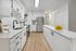 Modern kitchen with sleek white cabinetry, stainless steel appliances, and elegant hardwood flooring, offering a bright and inviting culinary space.