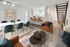 Elegant open-plan living and dining area with chic furnishings, modern kitchen with breakfast bar, and stylish staircase.