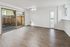 Bright and spacious living area with elegant wood flooring and large sliding glass doors opening to a serene outdoor space.