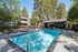 Inviting apartment complex with a sparkling pool, surrounded by lush greenery and modern amenities.