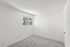 Bright and inviting empty room with fresh carpet and large window showcasing nature views.
