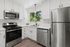 Modern kitchen with sleek stainless steel appliances, elegant white cabinetry, and a large window offering refreshing natural light.