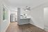 Modern open-concept kitchen with sleek stainless steel appliances, large windows for natural light, and elegant hardwood flooring.
