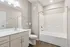 Elegant bathroom with modern fixtures, spacious vanity, and sleek tile bathtub showcasing contemporary design.