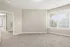 Bright and spacious room with plush carpeting and large windows allowing natural light.