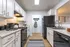 Modern kitchen featuring sleek black appliances, neutral cabinetry, and chic countertops with stylish accent decor.