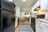 Contemporary kitchen with sleek black appliances, elegant white cabinetry, and a cozy dining nook ideal for modern living.