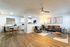 Modern open-plan living space featuring a stylish lounge with contemporary decor, cozy dining area, and elegant wooden flooring.
