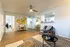 Inviting living room with stylish decor, wooden flooring, and warm natural light, showcasing a cozy seating area and chic wall art.
