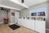 Modern, clean apartment laundry room with multiple high-efficiency washing machines and natural lighting.