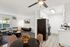 Charming open-plan apartment featuring a cozy living room with modern decor, adjacent to a sleek kitchen with white cabinetry and stainless steel appliances.