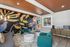 Vibrant apartment living room with bold mural, stylish teal chairs, and modern decor, offering a unique blend of comfort and artistic flair.