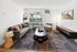Contemporary living room with a stylish gray sofa, sleek coffee table, and modern decor, featuring a large window with natural light.