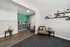Modern living area with stylish seating, vibrant turquoise backsplash, and sleek shelving enhancing the chic decor.