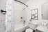 Modern bathroom featuring a chic shower curtain, elegant artwork, and stylish fixtures for a contemporary feel.