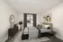 Elegant bedroom with modern decor, featuring a plush bed with stylish cushions, a sleek side table with lamps, and a large window for natural light.
